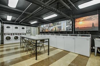 A laundry room with washing machines and a table with chairs